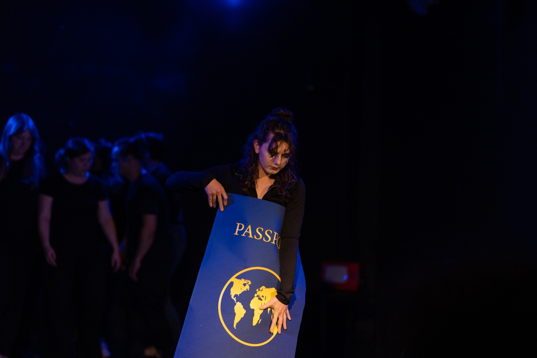 Performer holding an oversized passport prop
