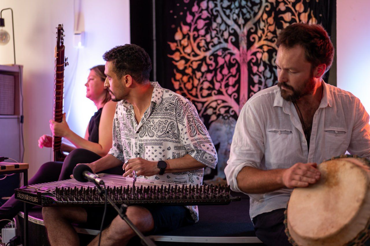Musicians playing santoor and djembe at an intimate session