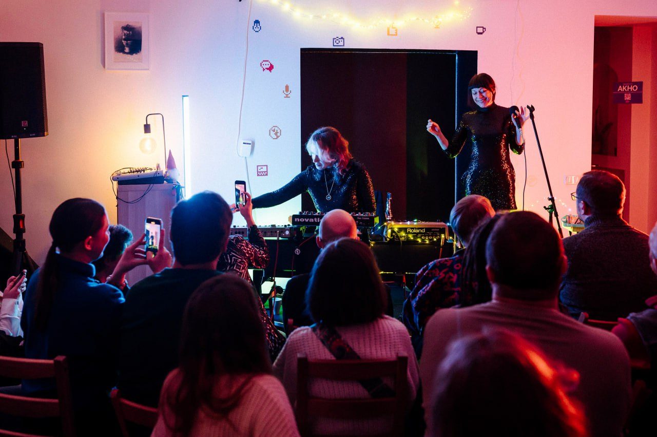 Duo performing an electronic set for a seated audience