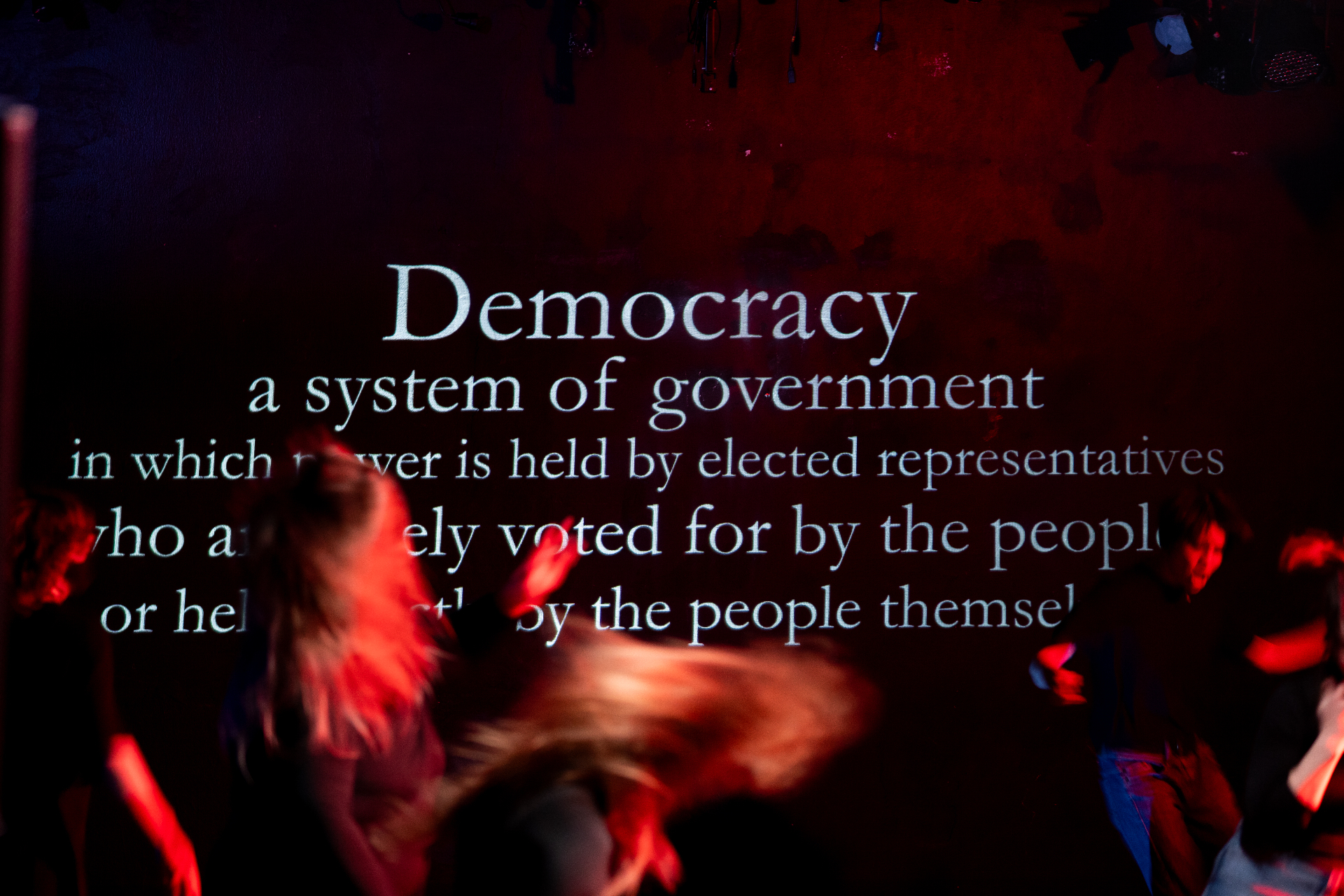 Stage projection of the definition of Democracy during the performance
