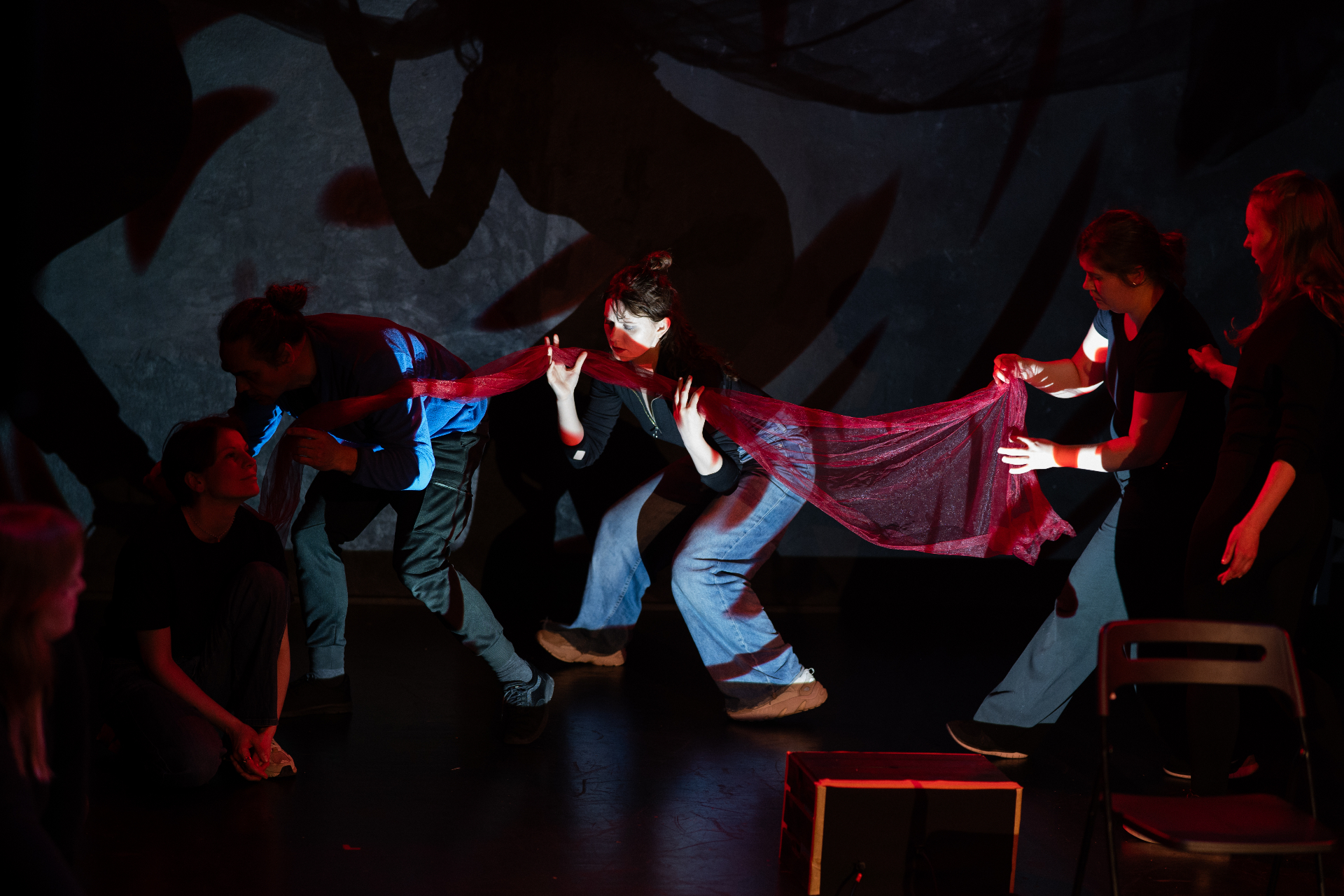 Performers holding a flowing red fabric on stage