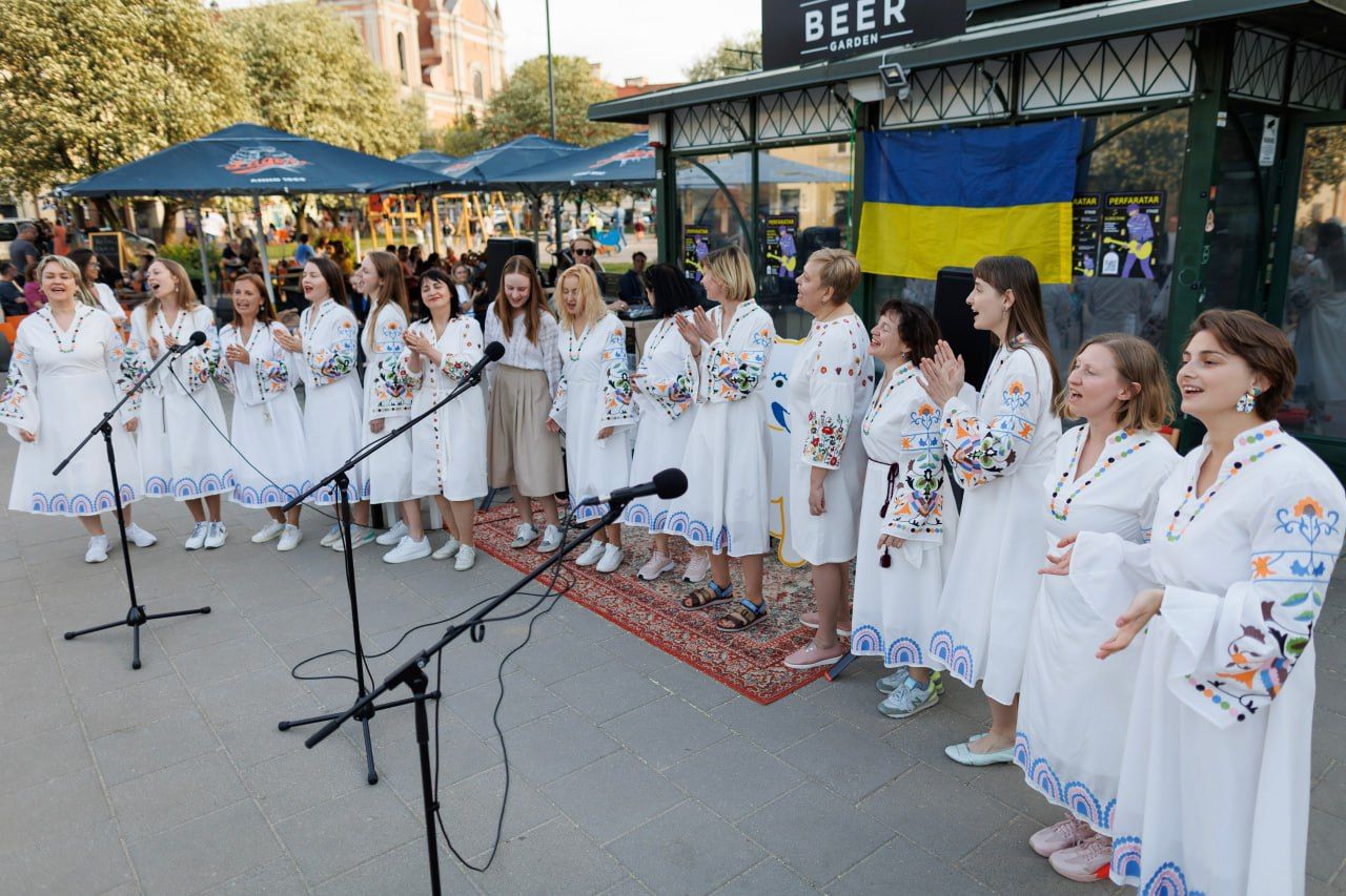 Women's choir in embroidered dresses singing outdoors