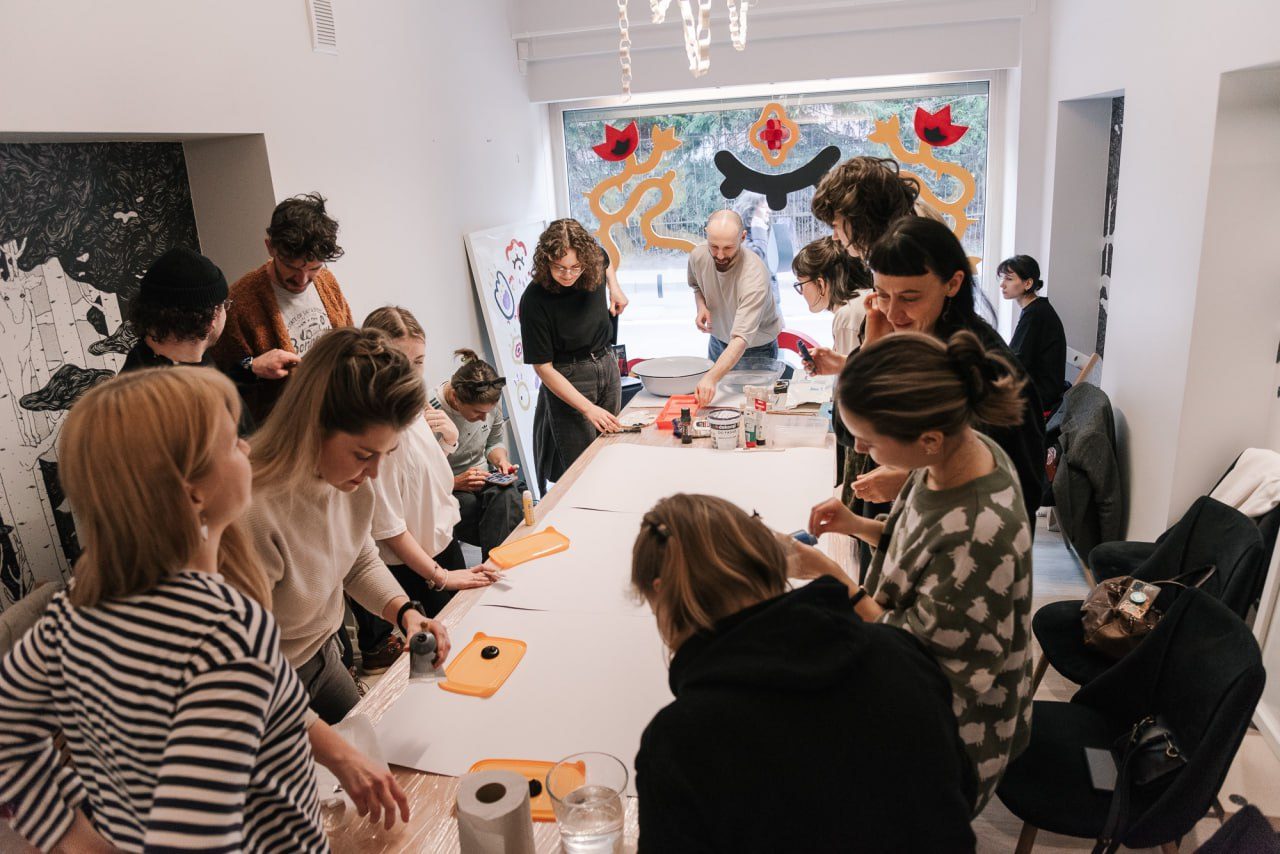 Participants at a printmaking workshop around a long table