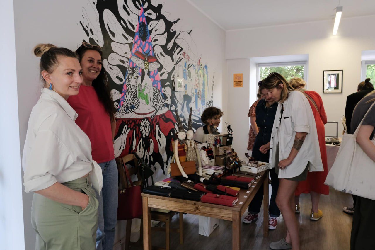 Visitors browsing a craft market in a gallery space