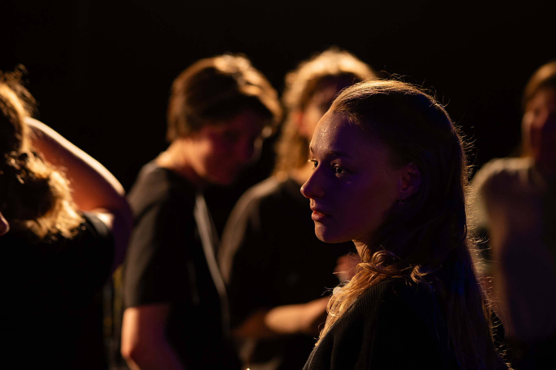 Performer watching attentively from the wings in warm light