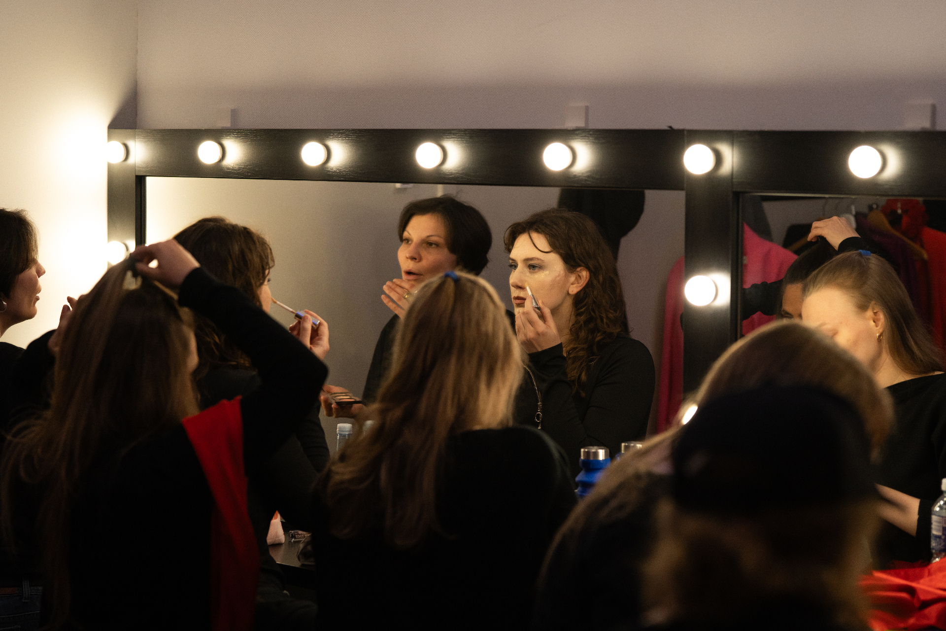 Backstage — performers in the mirror-lit dressing room