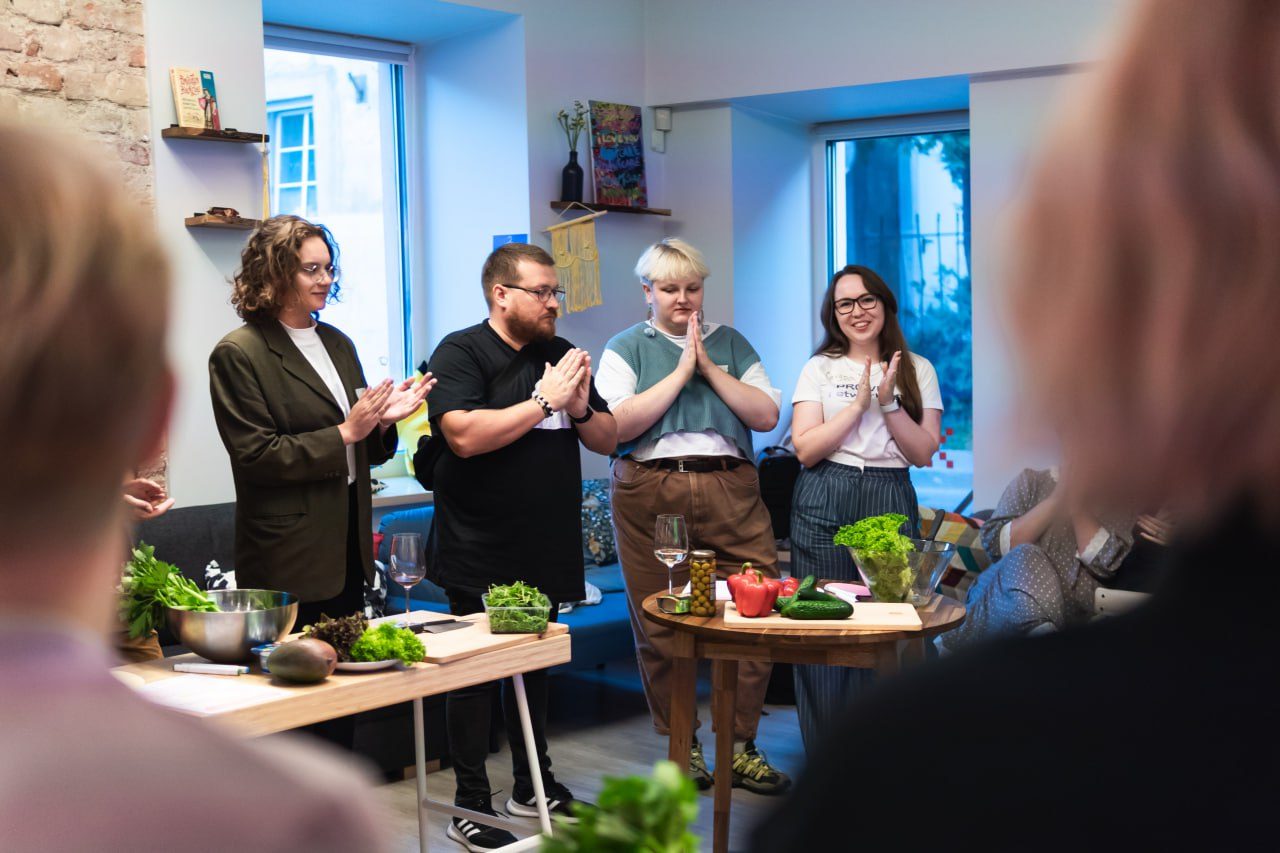 Hosts applauding at a cooking and community event