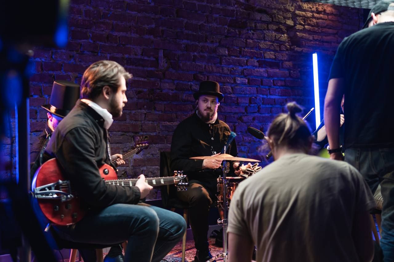 Band recording a live session in a brick-walled studio